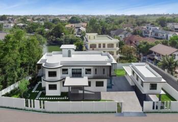 Aerial view of a large modern house with landscaped garden