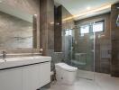 Modern bathroom with double sinks, a glass shower enclosure, and a large mirror