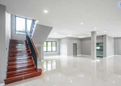 Spacious living area with staircase and large windows