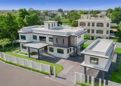 Elevated view of a modern two-story home with extensive surrounding landscape.