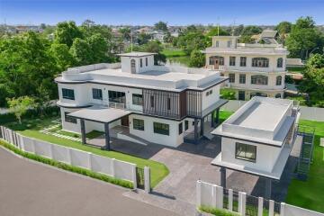 Elevated view of a modern two-story home with extensive surrounding landscape.