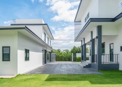 Modern exterior of a residential property with two separate buildings and a lush lawn