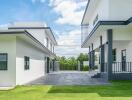 Modern exterior of a residential property with two separate buildings and a lush lawn