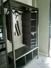Open closet with hanging clothes and storage compartments