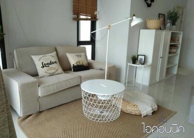 Cozy living room with a sofa, white coffee table, and wooden sideboard