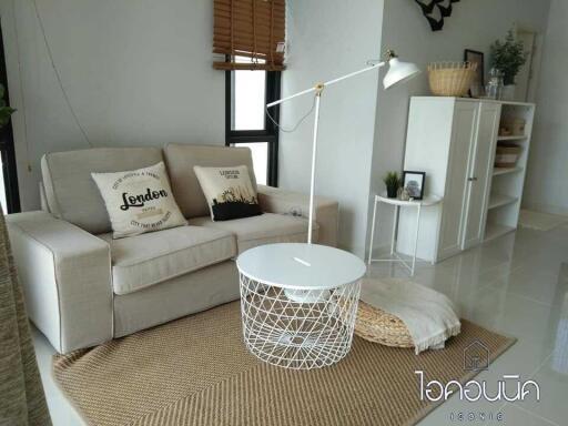 Cozy living room with a sofa, white coffee table, and wooden sideboard