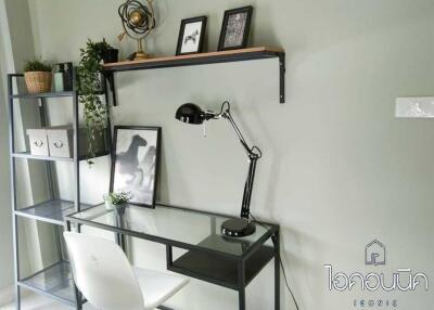 Home office with desk, chair, lamp, shelf, and decorations