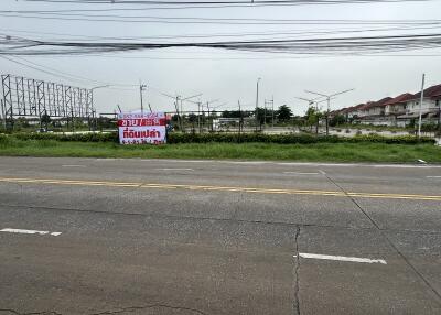 vacant land with houses in background