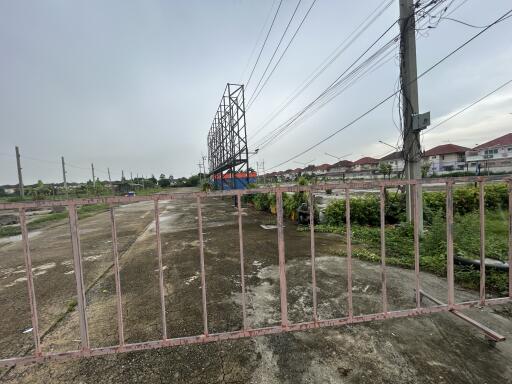 View of an empty lot with a gate and power lines