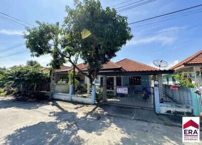 Front view of a single-story house with a tiled roof and a fenced yard