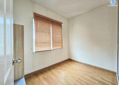 Empty bedroom with wooden floor and window with blinds
