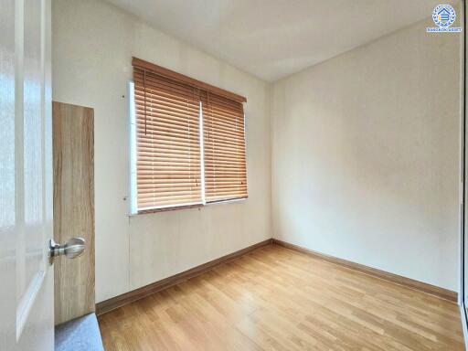 Empty bedroom with wooden floor and window with blinds