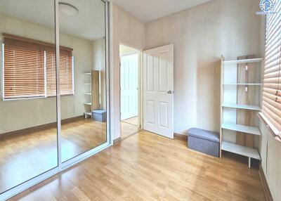 Bedroom with mirrored wardrobe and wooden flooring