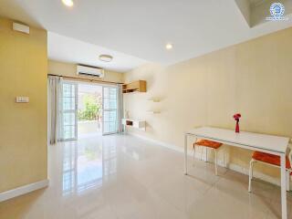 Modern living room with large windows, dining table and chairs