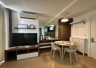 Modern living area with a dining space and a TV