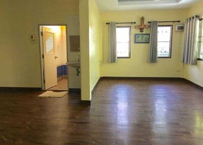 Spacious living room with wooden flooring and large windows