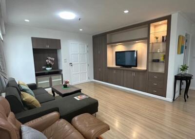 Modern living room with built-in wooden entertainment center and comfortable seating