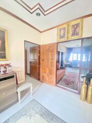 A well-decorated living area with wooden doors, framed art, and modern furnishings