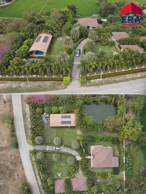 overhead view of a property with main house, secondary building, driveway, and landscaped yard