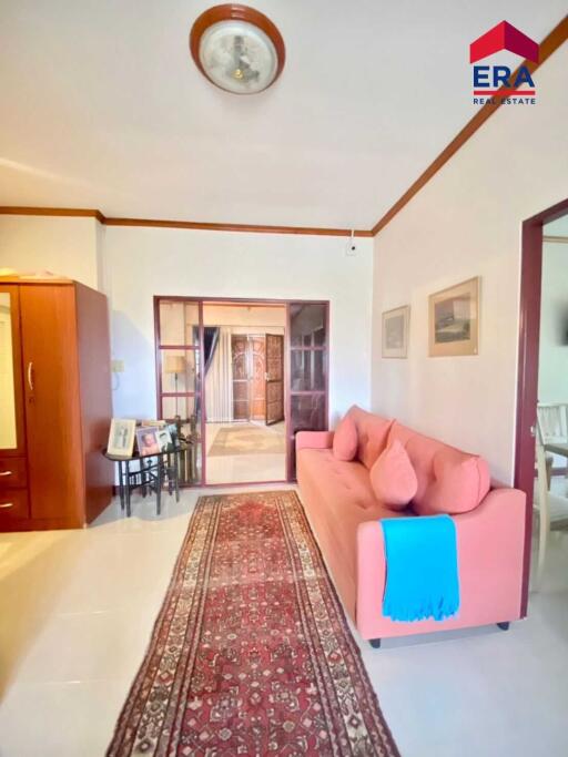 Comfortable living room with pink couch and patterned rug