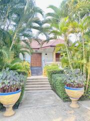 Entrance of a house surrounded by lush greenery