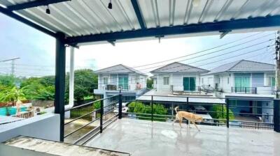 Spacious balcony with roof cover and view of neighboring houses