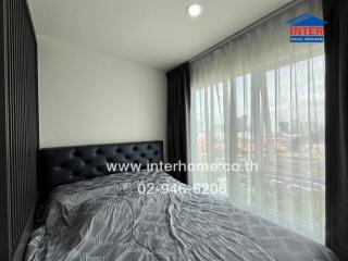 Bedroom with large window and city view