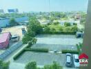 View of parking area from building with greenery