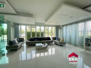 Spacious modern living room with large windows and comfortable seating