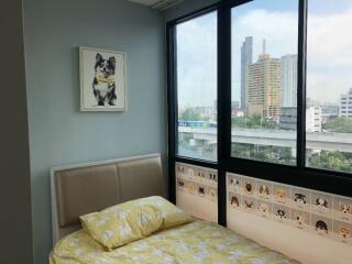 Cozy bedroom with a large window and city view