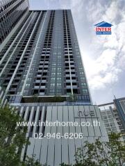 High-rise residential building exterior with real estate agency branding