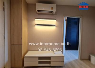 Living room with air conditioner and wall-mounted shelves.