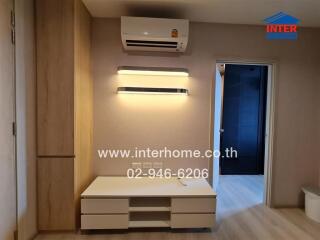 Living room with air conditioner and wall-mounted shelves.