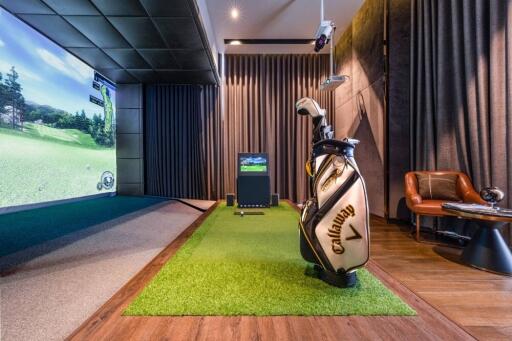 Indoor golf simulator room with golfing equipment and seating