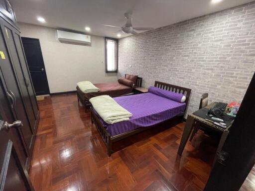 Spacious bedroom with two beds, wardrobe, desk, and air conditioning
