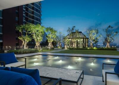 Luxurious outdoor area with a pool and lush greenery at night