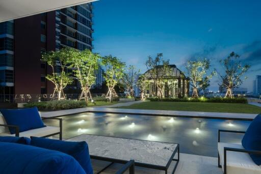 Luxurious outdoor area with a pool and lush greenery at night