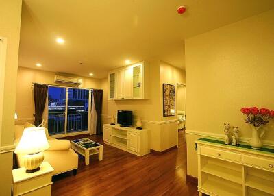 Well-lit living area with hardwood floors and modern furnishings