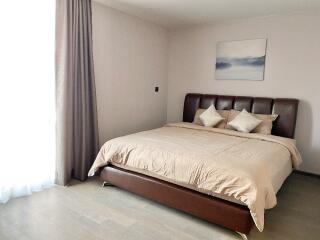 Modern bedroom with brown bedframe and beige bedding