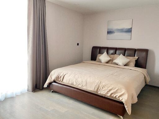 Modern bedroom with brown bedframe and beige bedding