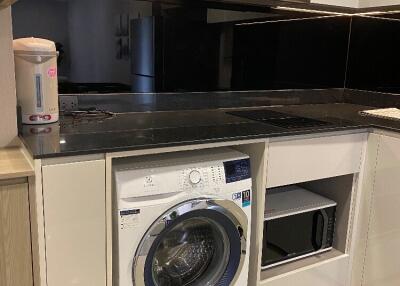 Modern kitchen with washing machine and microwave