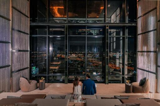 Spacious living area with large floor-to-ceiling windows and night city view