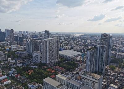 Aerial view of a city with high-rise buildings and a river in the background