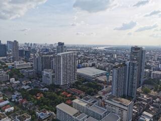 Aerial view of a city with high-rise buildings and a river in the background