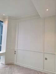 Empty living room with white panelled walls and ceiling lights
