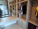 Walk-in closet with wooden shelves and hanging space