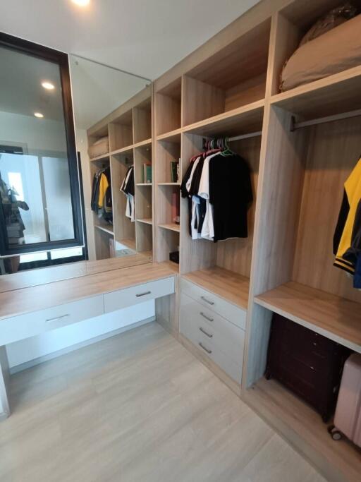 Walk-in closet with wooden shelves and hanging space