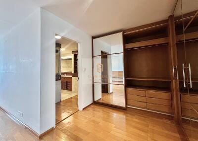 Bedroom with built-in wooden wardrobes and attached bathroom