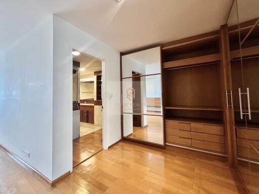 Bedroom with built-in wooden wardrobes and attached bathroom