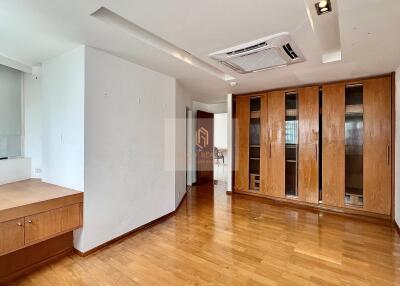 Spacious living room with wooden flooring and built-in wooden cabinets